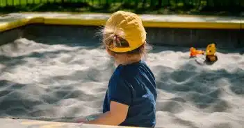 girl playing on sand box